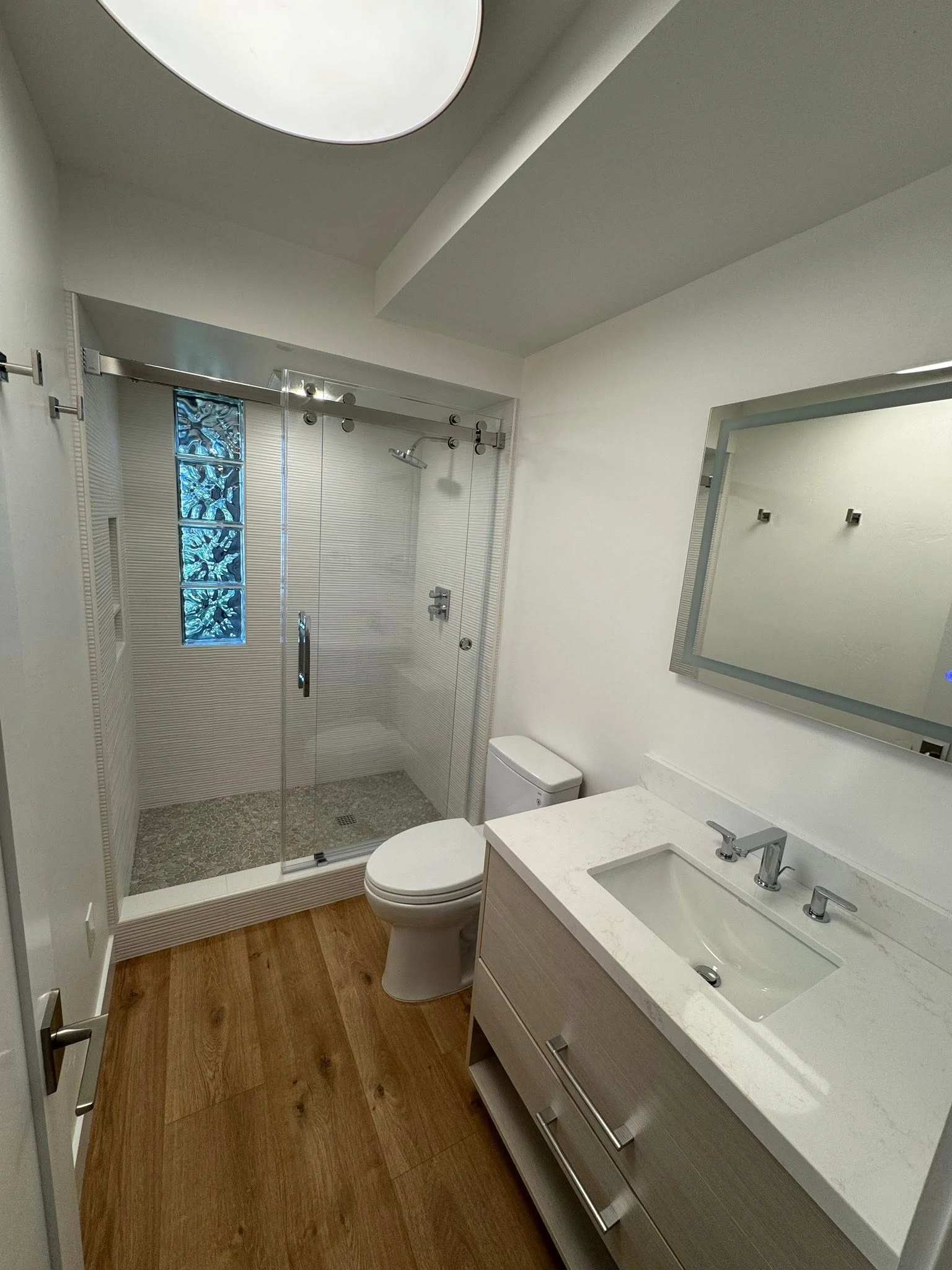 Complete bathroom remodel with glass shower and skylight