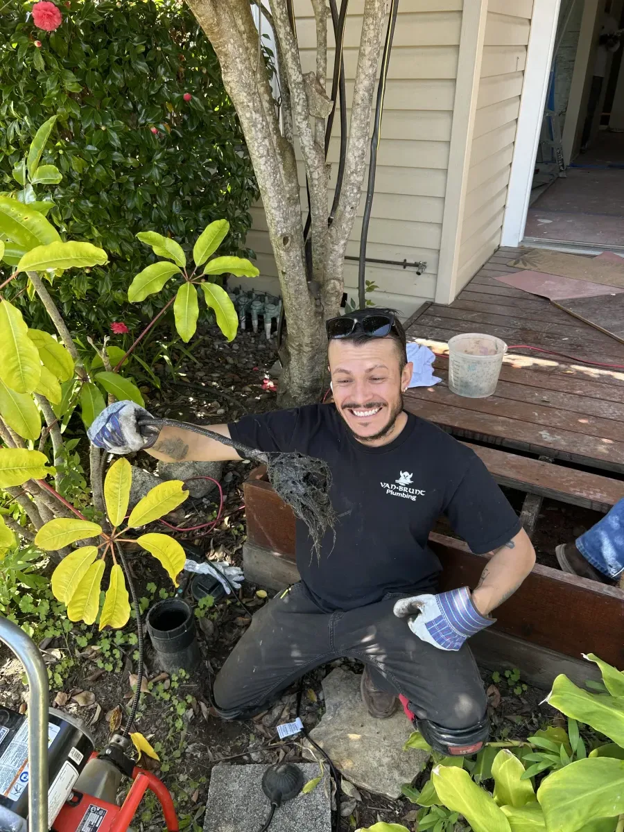 Van Brunt Plumbing team member performing drain cleaning on-site