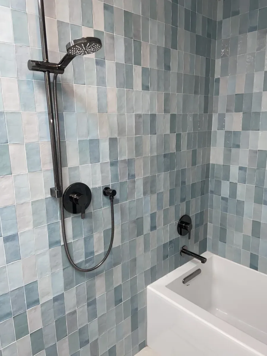 Shower interior with blue-green zellige tile and matte black fixtures