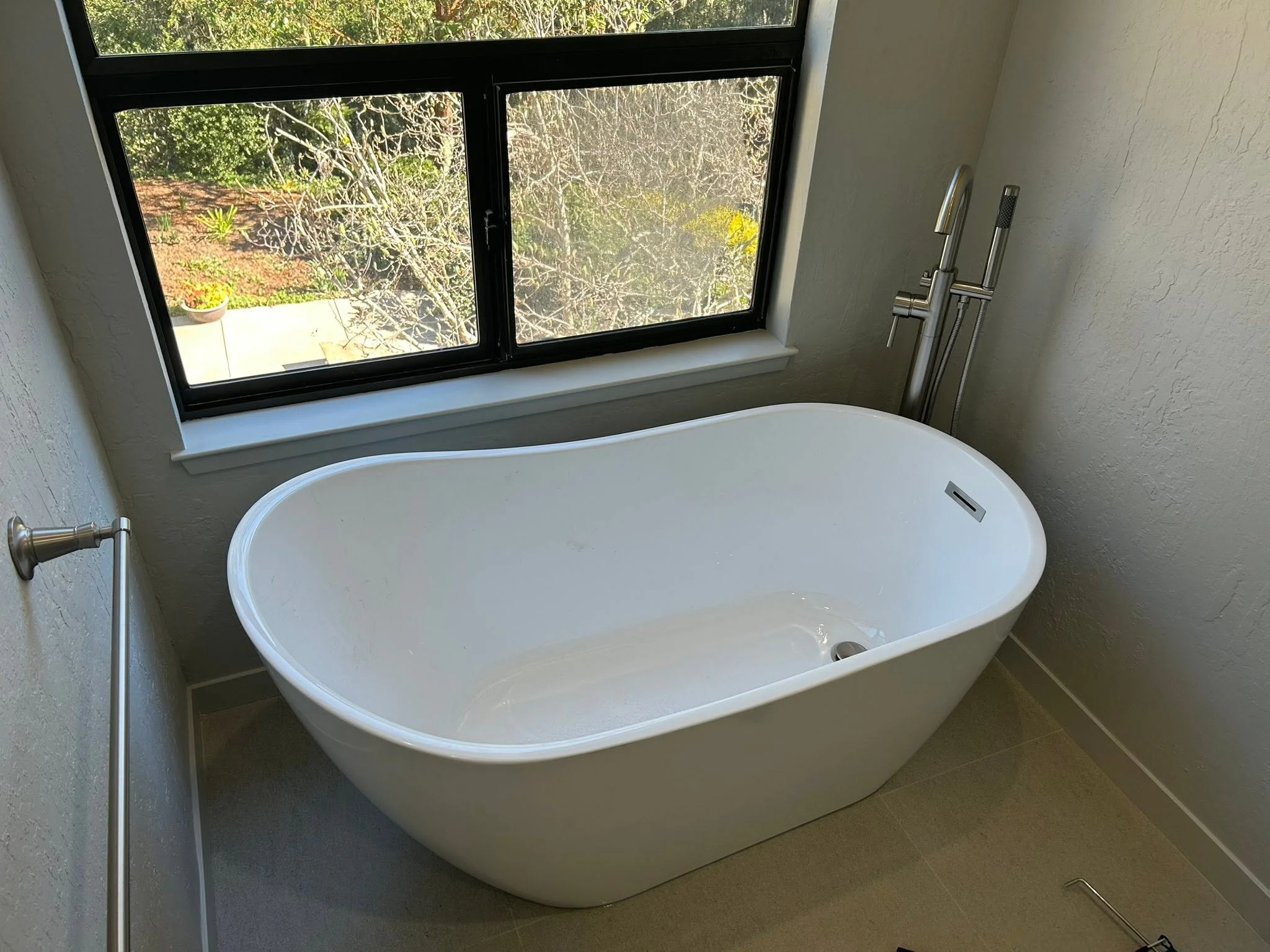 Freestanding bathtub installation with window view